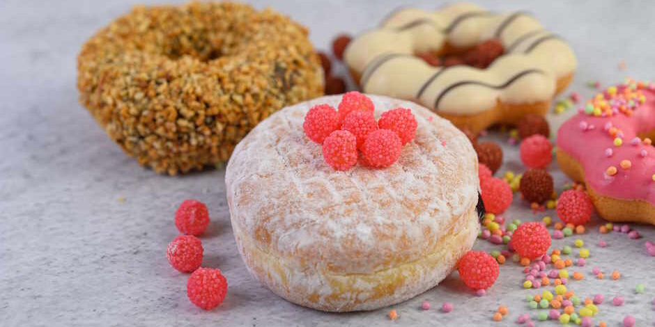 Donuts sprinkled with icing sugar and candy on a white backgroun «Жирный четверг» когда празднуют в этом году - Orzeł Biały